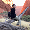 Thiya sitting on a fallen tree at Uluru